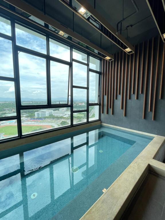 a swimming pool in a building with windows at Seaview condo in Siracha (Free onzen) in Si Racha