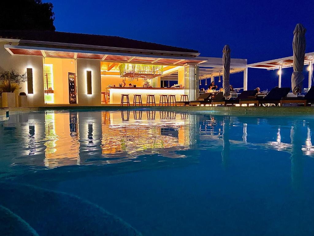 a swimming pool in front of a house at night at VILLA ALEXIS in Megali Ammos