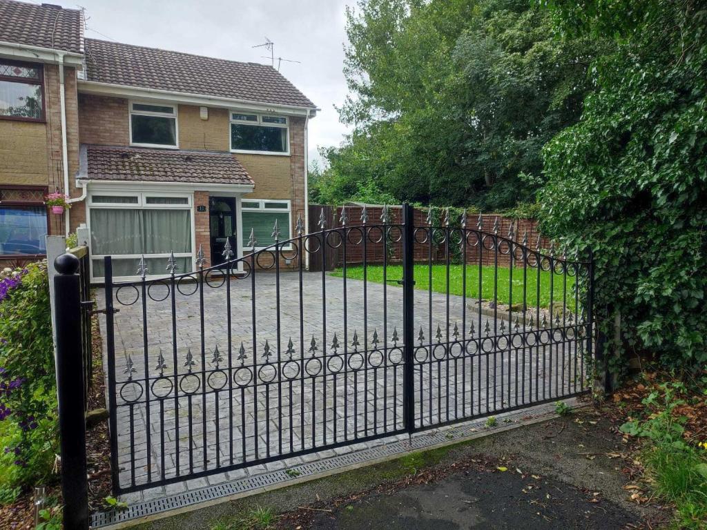 uma cerca de ferro preto em frente a uma casa em Serendipity em Manchester