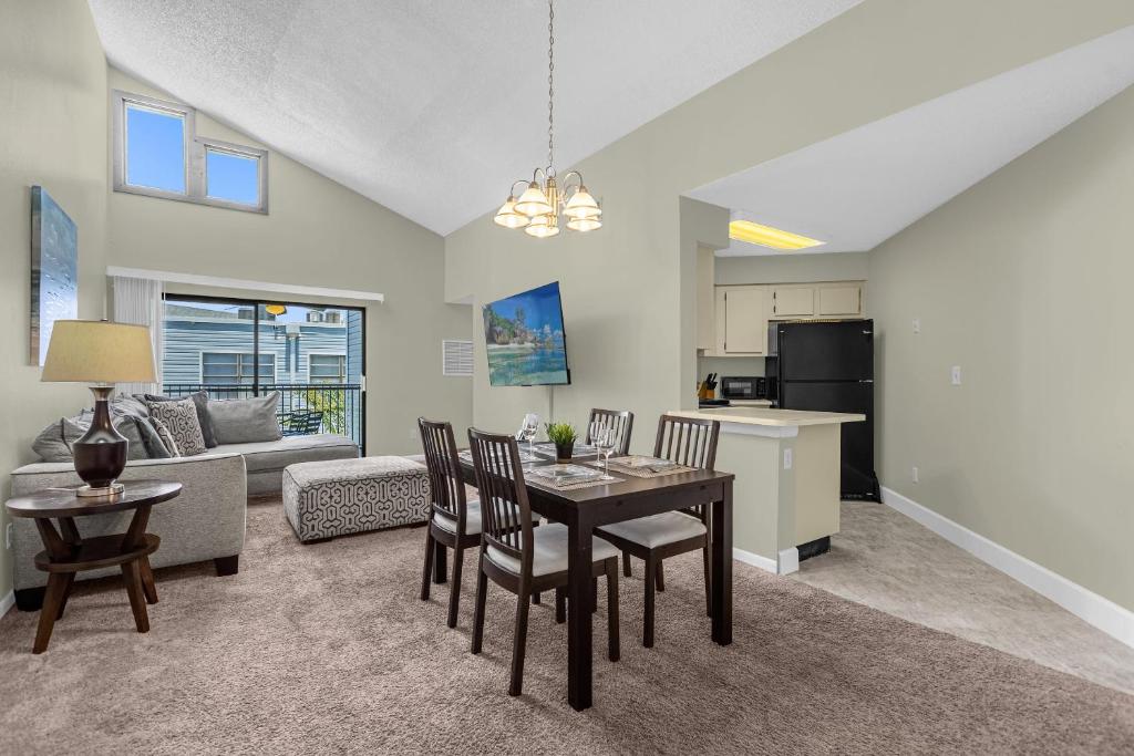 a kitchen and living room with a table and chairs at Modern Cozy 2BR Condo Near Disney in Orlando