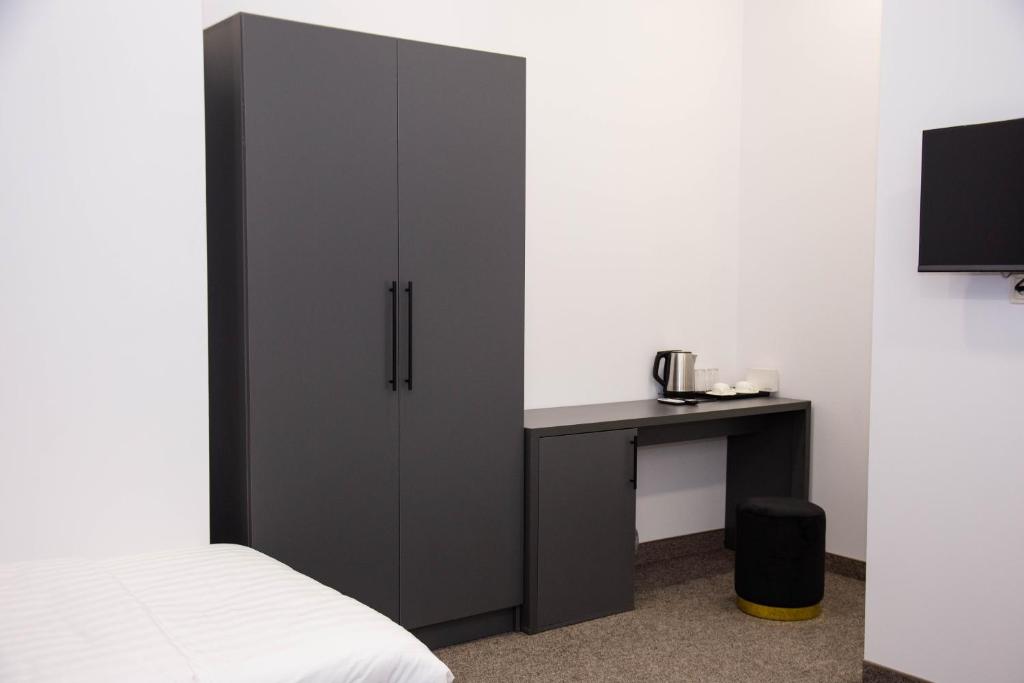 um quarto com um armário preto ao lado de uma secretária em Port Plaza YVN em Pʼarakʼar