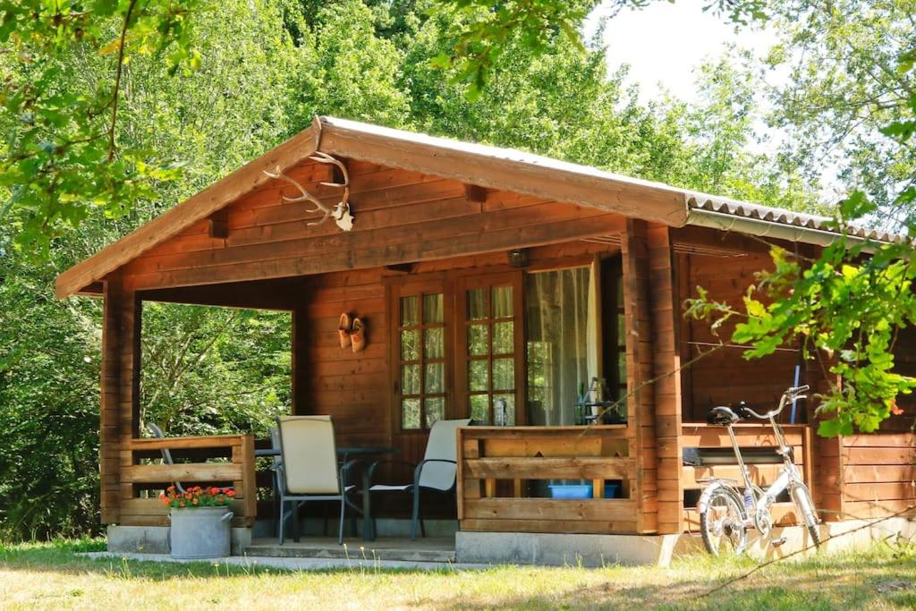Cabaña de madera pequeña con 2 sillas y mesa en Domaine La Faix, Gite la Forestière en Saint-Plaisir
