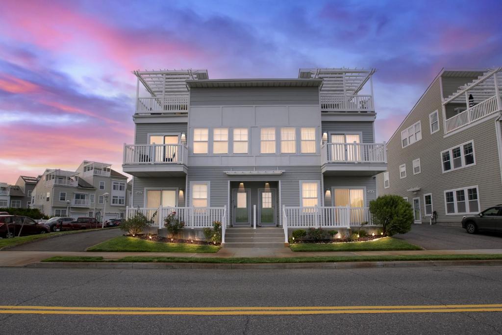 a gray house with a sunset in the background at Stunning Beachfront Queens Getaway townhouse in Far Rockaway