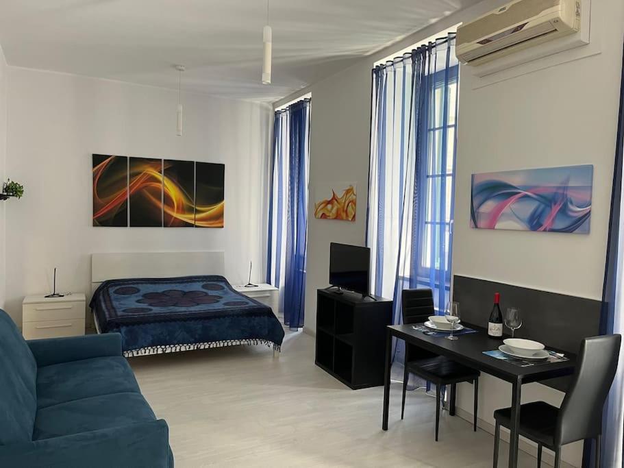 een woonkamer met een blauwe bank en een bed bij feelgood in Trieste