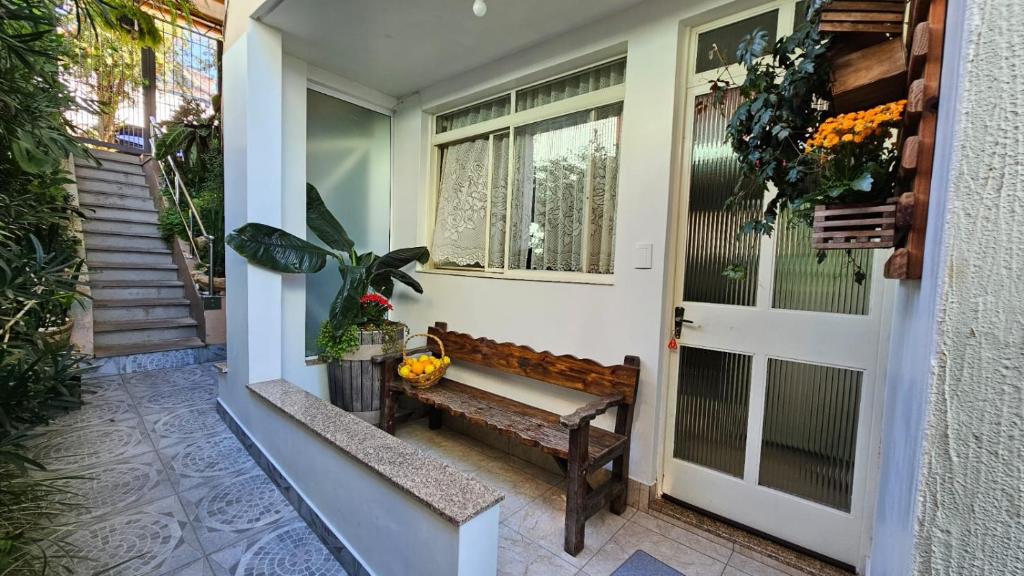 Residência bem localizada em Bento Gonçalves في بينتو جونكالفيس: شرفة مع مقعد أمام الباب