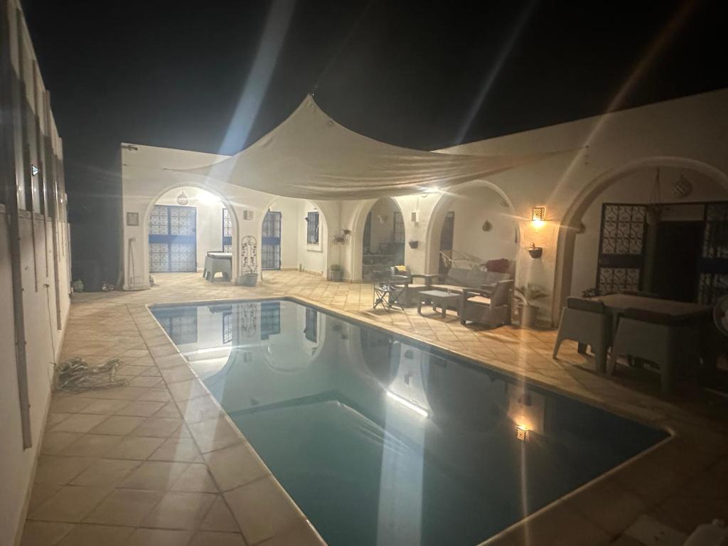 a large swimming pool in a living room at Kmi in Zarzis