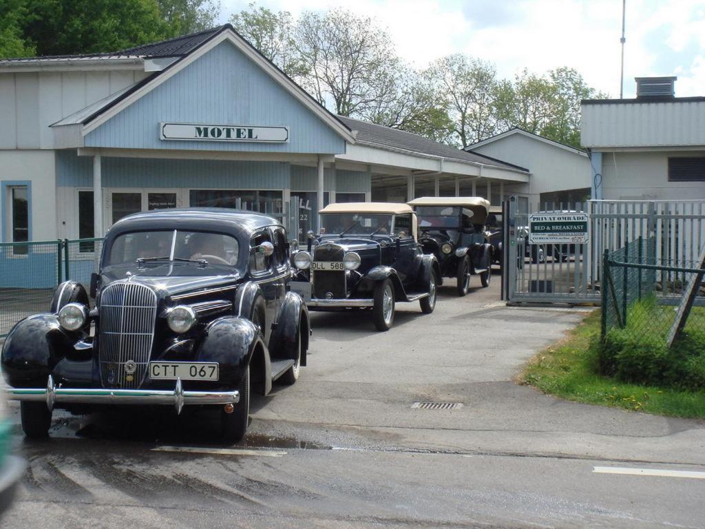 trzy stare samochody zaparkowane przed budynkiem w obiekcie Fleninge Classic Motel w mieście Fleninge