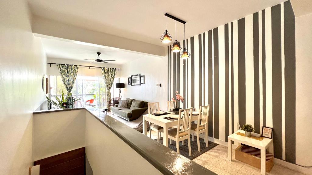 uma cozinha e sala de estar com uma parede listrada em The Roomah em Bentong