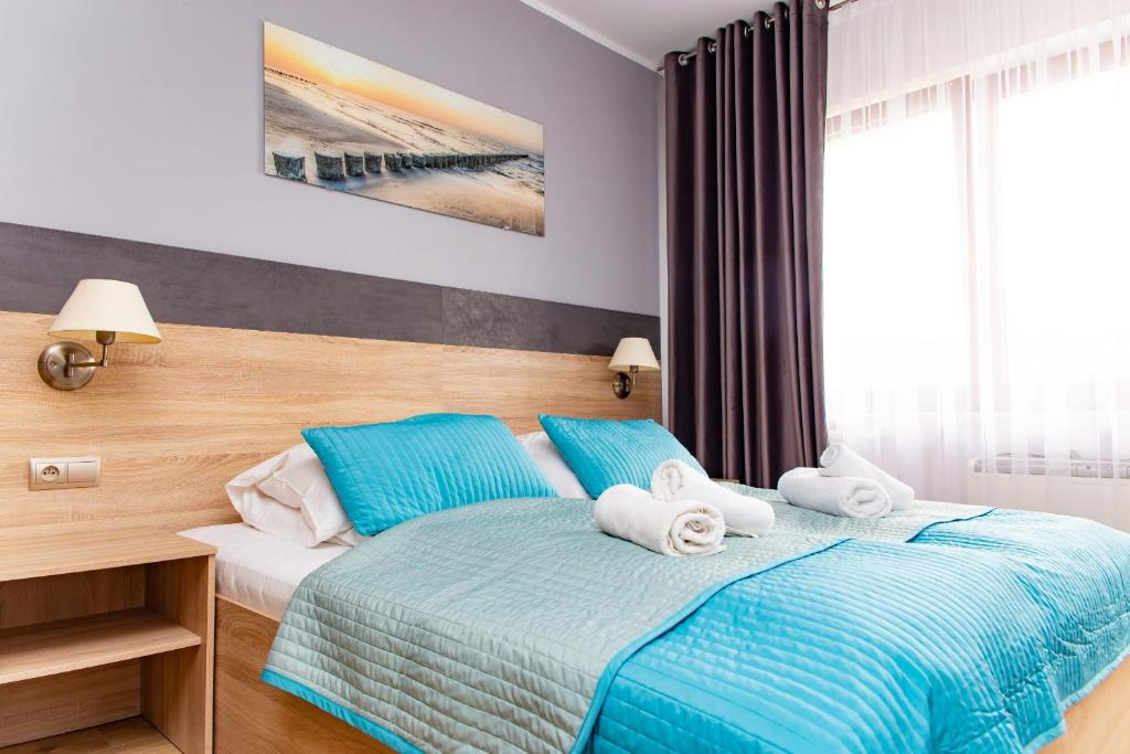 コウォブジェクにあるApartamenty PROMENADA-Arkaのベッドルーム1室(青いシーツとタオル付きのベッド1台付)
