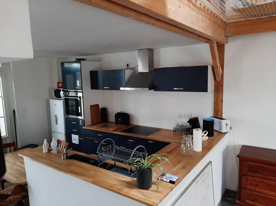 a kitchen with a wooden counter top in a room at Maison proche gare et commodités in Le Mans