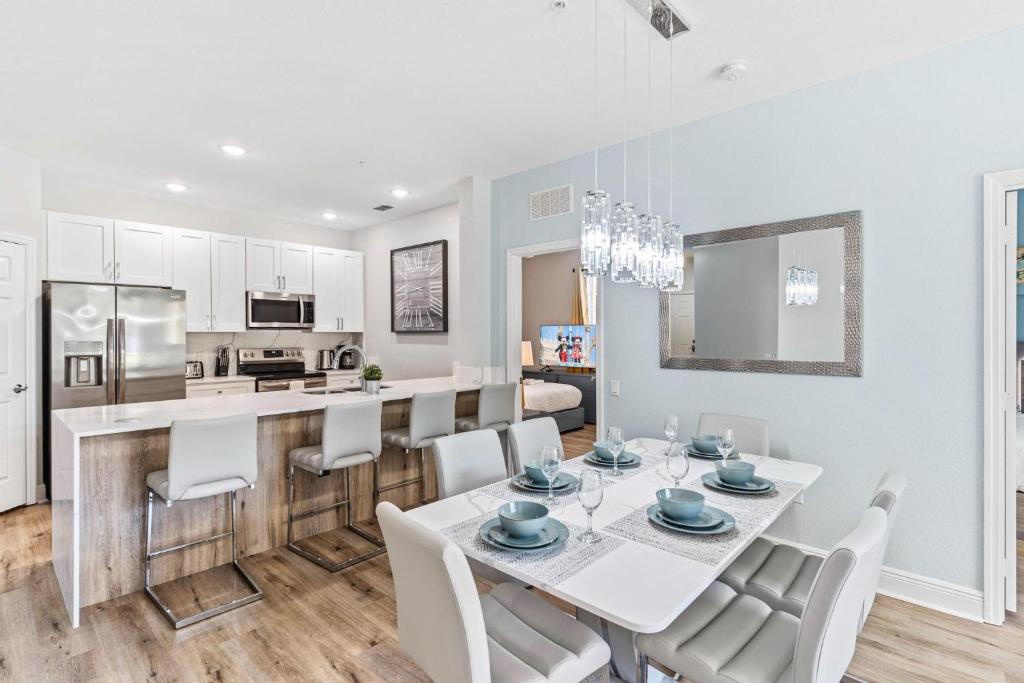 a kitchen and dining room with a white table and chairs at The Epic Dublin Vista Cay Orlando in Orlando