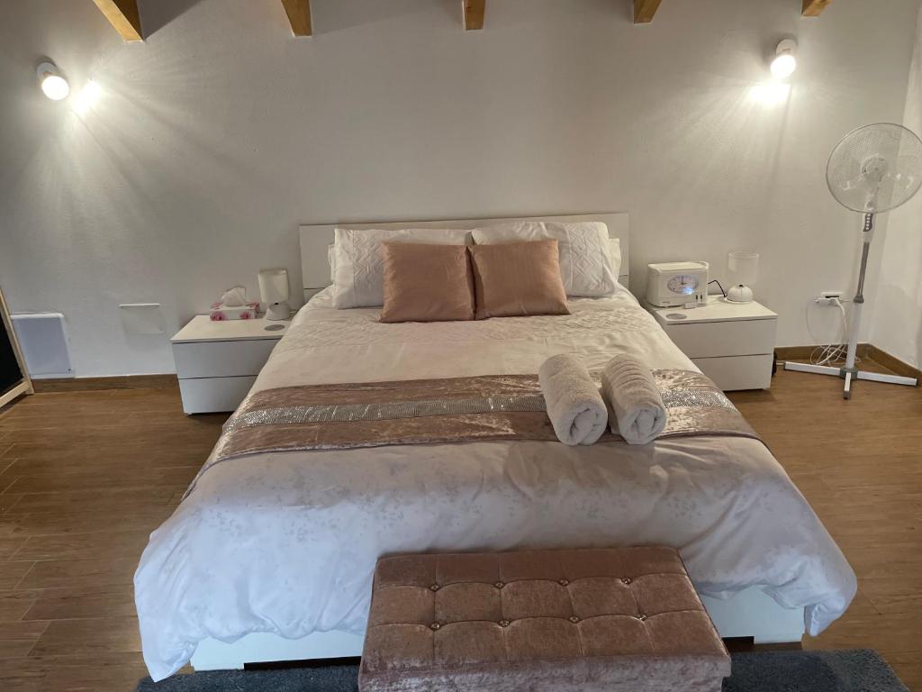 ein Schlafzimmer mit einem großen Bett mit zwei Nachttischen in der Unterkunft Charming two bedroom house in Strevi