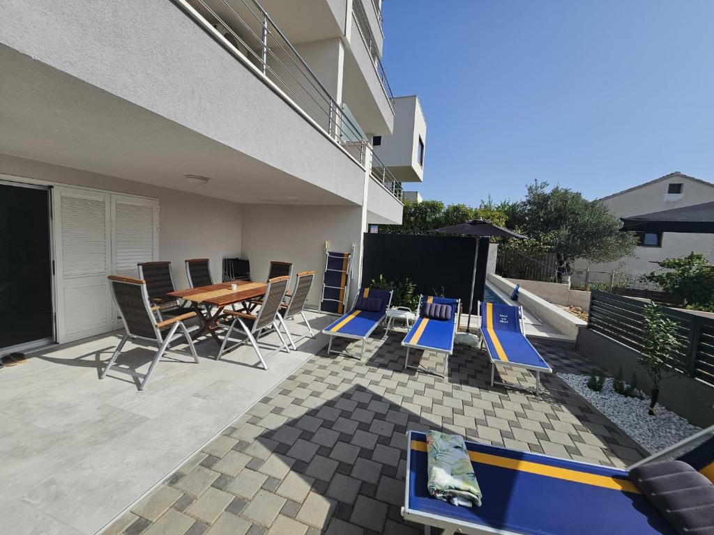 a patio with blue chairs and a table on a balcony at Villa BOTIĆ in Trogir