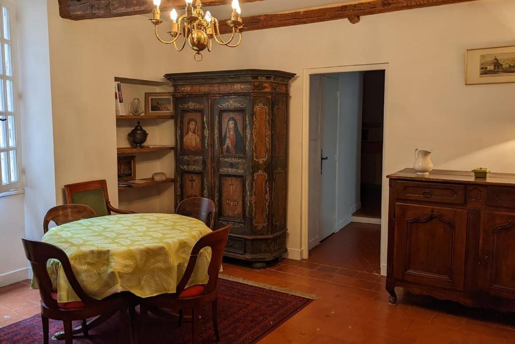 une salle à manger avec une table et une grande armoire en bois dans l'établissement Les gites d'intervalles, à Entrevaux