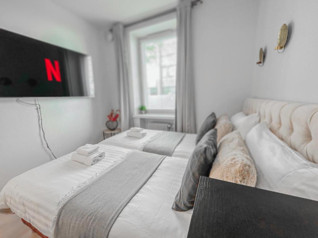 2 Betten in einem Zimmer mit einem TV an der Wand in der Unterkunft Residential Hotels Helsinki Center in Helsinki