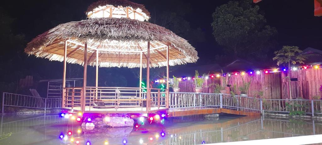 a pavilion with a large umbrella and lights at Suối giàng A Chông homestay in Yên Bái
