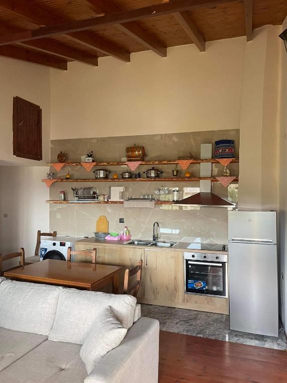 a kitchen with a refrigerator and a table in a room at Athens apartment Greece in Sarandë