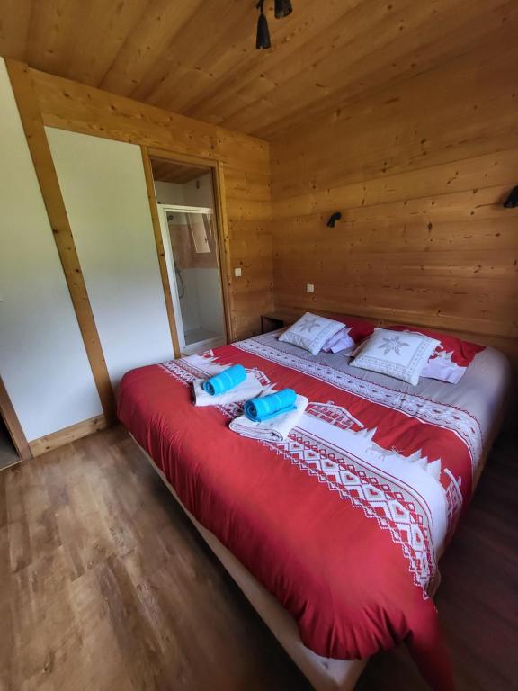 a large red bed in a wooden room at La petite Anfiane in Le Grand-Bornand