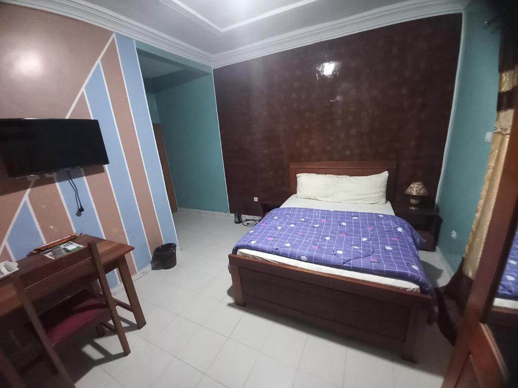 - une petite chambre avec un lit et une table dans l'établissement SAM RESIDENCE Jàmm ak Cofeel, à Saint-Louis