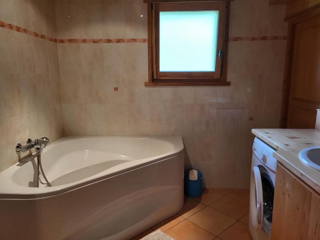 a bath tub in a bathroom with a window at La petite Anfiane in Le Grand-Bornand