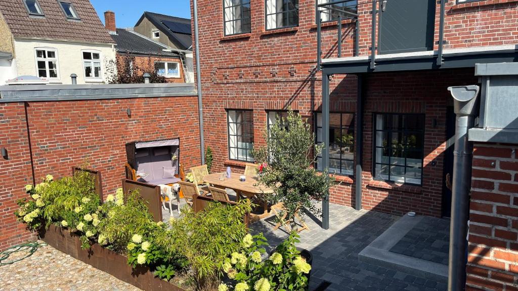 a brick building with plants in a courtyard at Loftwohnung 1 Simmerdeis an der Gracht in Friedrichstadt