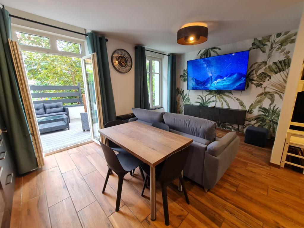 un salon avec une table en bois et un canapé dans l'établissement 2 pièces, SPA et terrasse, Nancy Thermal, à Nancy