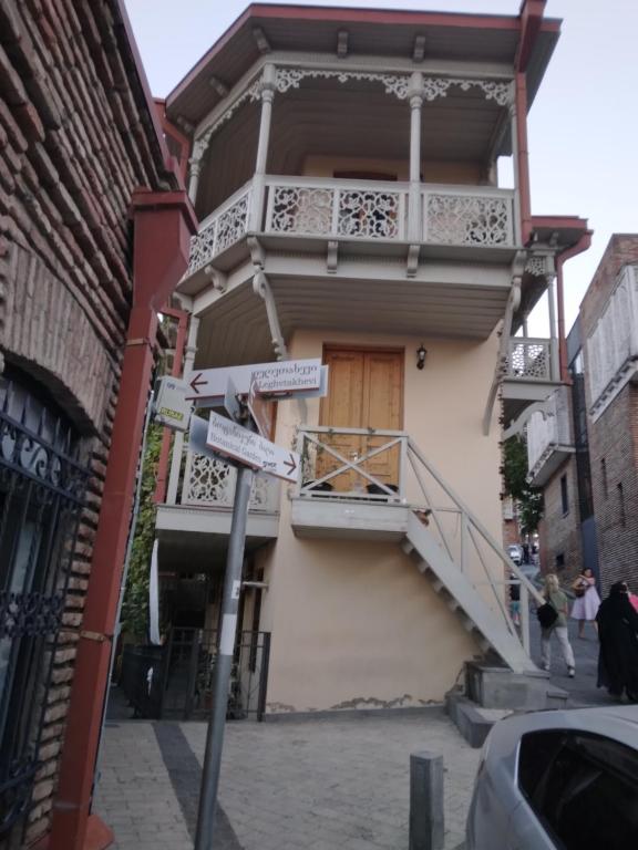 un cartello stradale di fronte a un edificio con balcone di Vazi a Tbilisi City