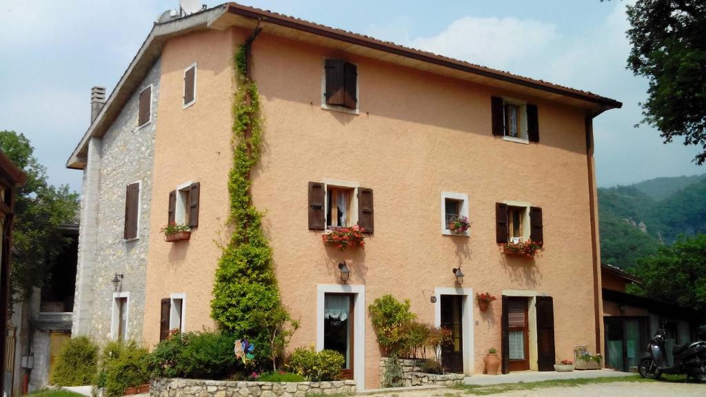 um grande edifício com hera crescendo sobre ele em Agriturismo La Part em San Zeno di Montagna