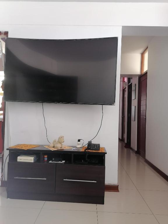 TV de pantalla plana grande colgada en la pared en Residencial Las Torres de Salaverry, en Chiclayo