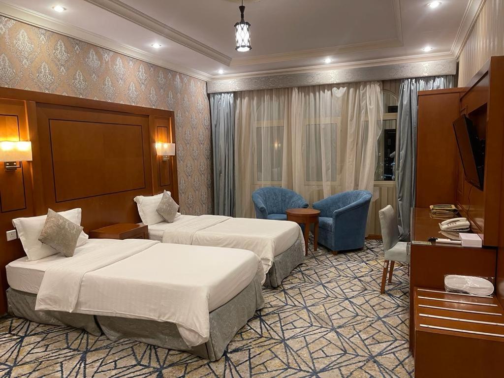 a hotel room with two beds and a television at رغد الشاطئ للاجنحة الفندقية in Jeddah