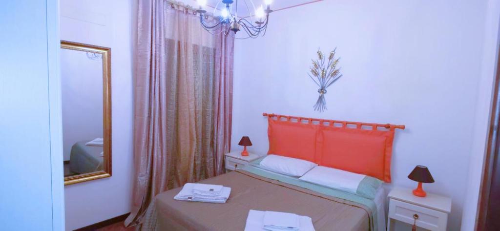 um quarto com uma cama com uma cabeceira vermelha e um espelho em SEGESTA Nouveau Bedding em Salemi
