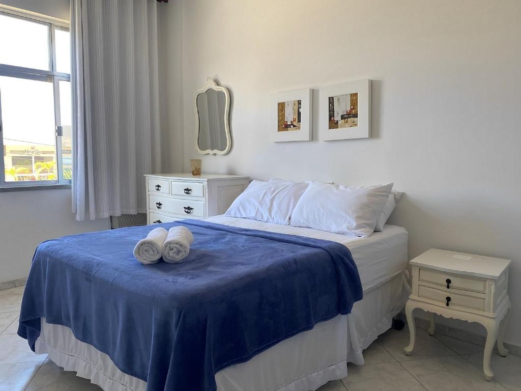 een slaapkamer met een bed met twee handdoeken erop bij Apto a beira mar no Centro - WIFI 200MB - TV Smart - Cozinha equipada - Portaria 24h - Ar condicionado in Rio das Ostras