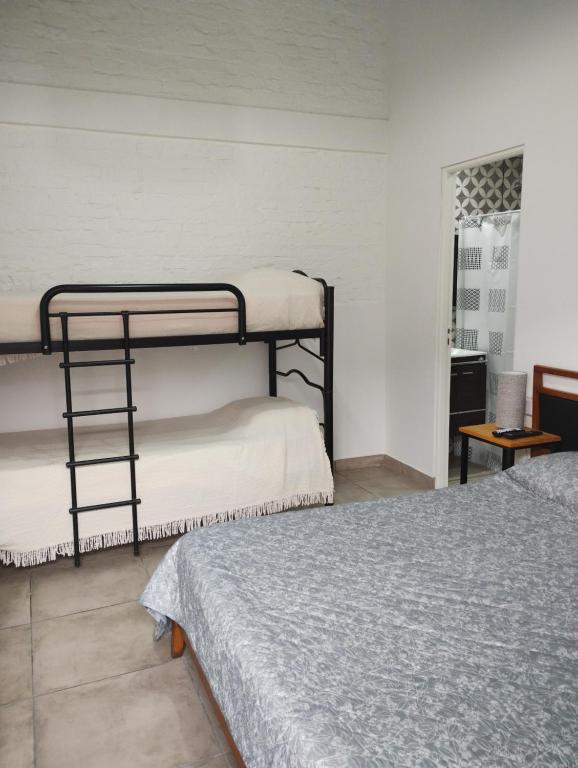 1 dormitorio con 2 literas y mesa en Habitaciones con baño privado zona centro - Salta Capital en Salta