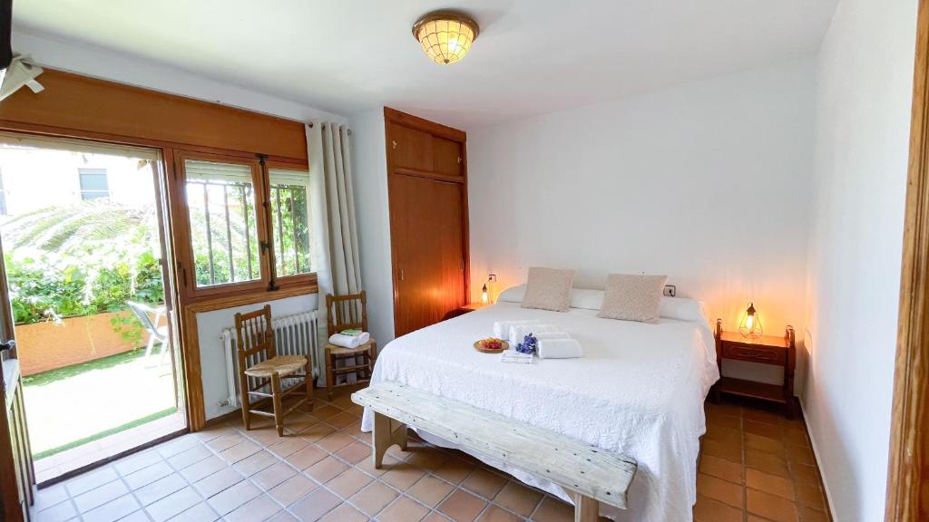 een slaapkamer met een wit bed en een raam bij Villa del Jerte in El Torno