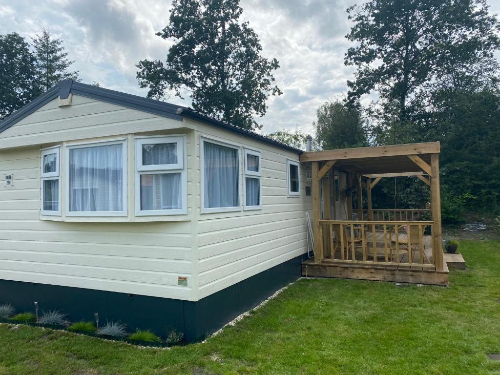 een tiny house met een veranda en een terras bij Chalet Olm 29 in Zoerte