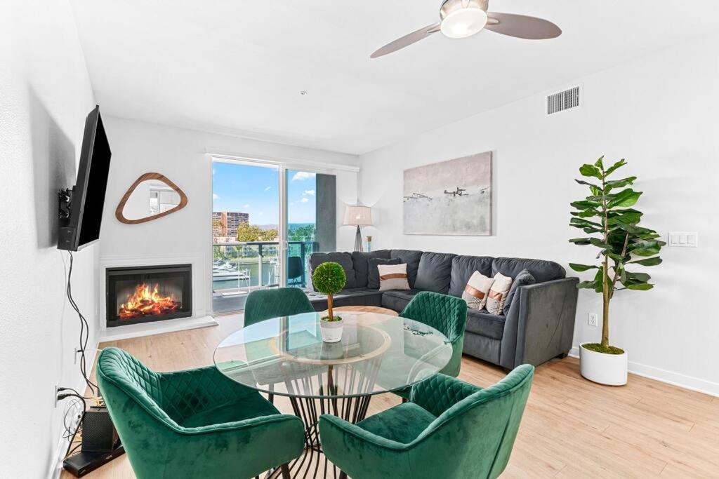 a living room with a glass table and green chairs at Emerald Gem 2bedroom 2bath With Full Marina View in Los Angeles