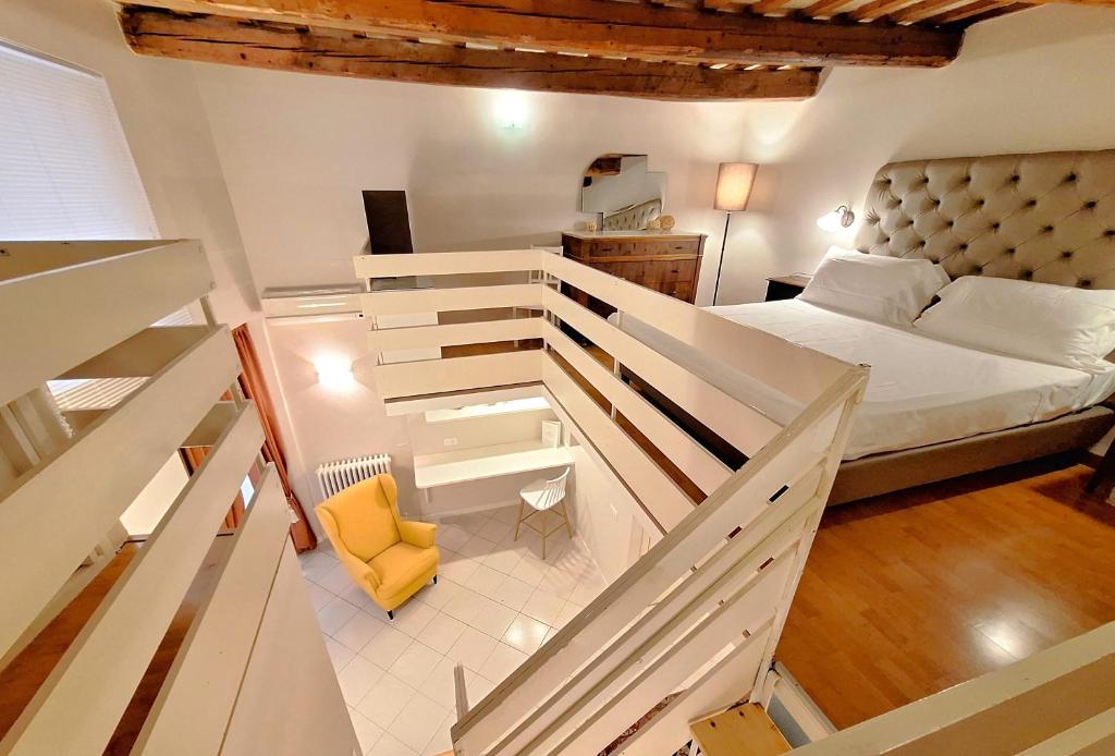1 dormitorio pequeño con 1 cama y 1 silla amarilla en Hotel Lauri, en Macerata