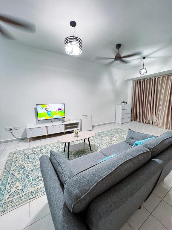sala de estar con sofá y TV de pantalla plana en Homestay Ar-Rayyan 3 Ketereh, en Ketereh