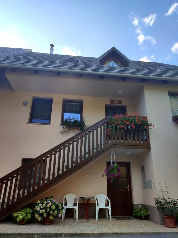 a house with a balcony with a table and chairs at Počitniško stanovanje Aurora in Bovec