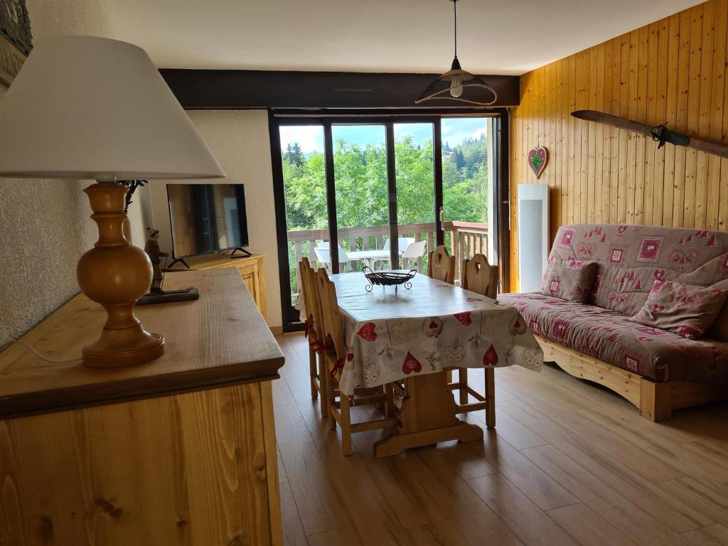 a living room with a table and a couch at CHARMANT T2 de MONTAGNE à la STATION DES ROUSSES AVEC BALCON ET GARAGE in Les Rousses