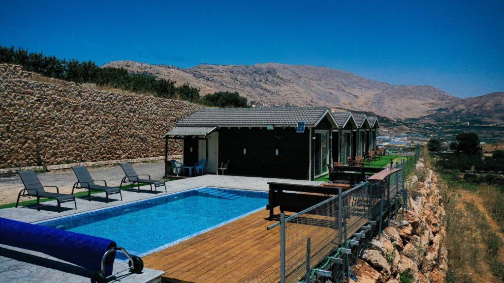 une maison avec une piscine à côté d'une montagne dans l'établissement פסגת גן עדן בחרמון, à Majdal Shams