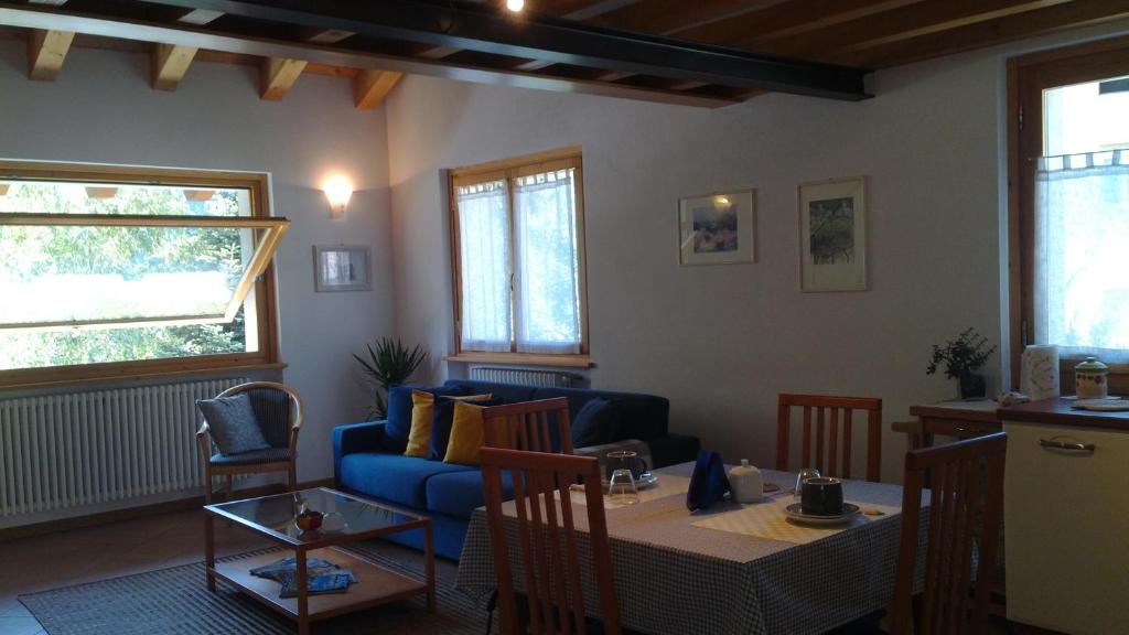 a living room with a table and a blue couch at B&B I Pioppi in Chiavenna