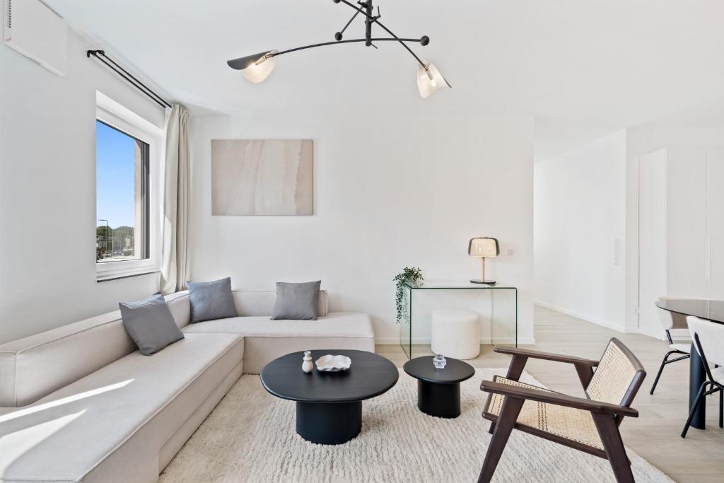 a white living room with a couch and a table at Stylish Retreat in Bivange Roeser in Roeser