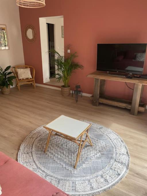 un salon avec une table basse et une télévision à écran plat dans l'établissement Charmante maison de location à Blauzac (30), à Blauzac