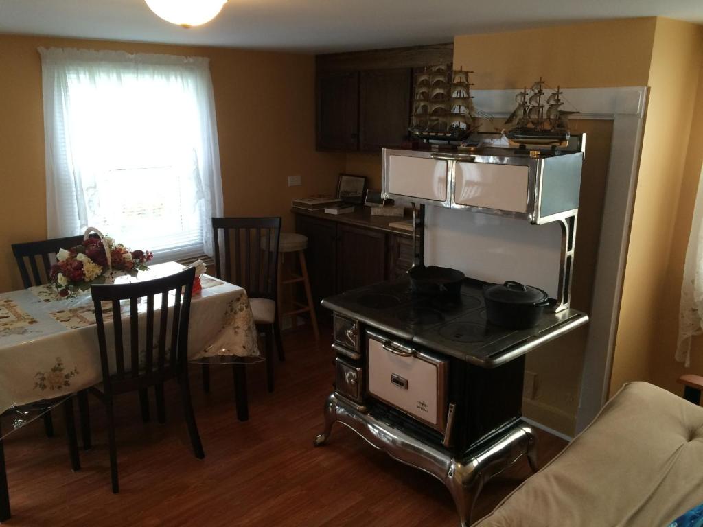 a kitchen and dining room with a stove and a table at Dorman's Manor in Bonavista