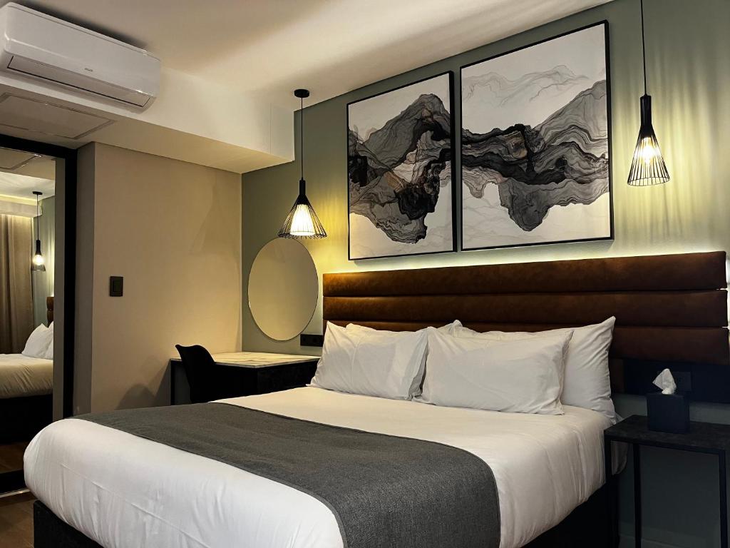 ブリッツにあるRiverleaf Hotelのベッド1台付きの客室で、壁に2枚の写真が飾られています。