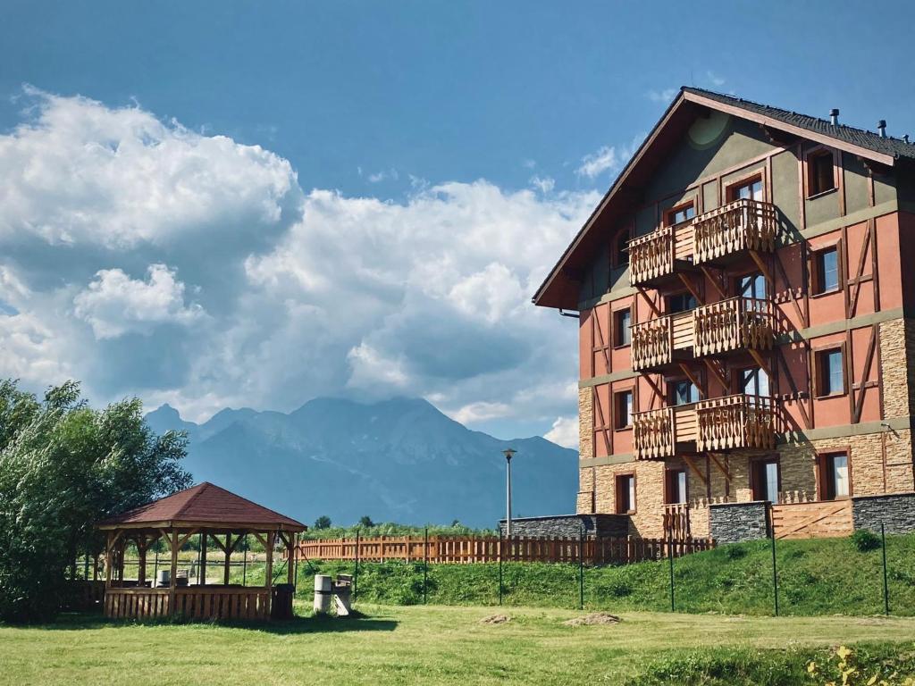 a large building with a gazebo next to it at Holiday Resort Tatry in Veľká Lomnica