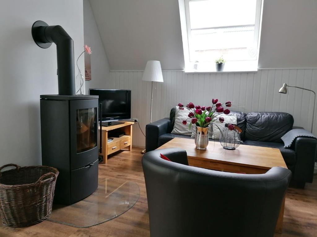 ein Wohnzimmer mit einem Sofa und einem Holzofen in der Unterkunft Ferienhaus-Slanitz in Harlesiel