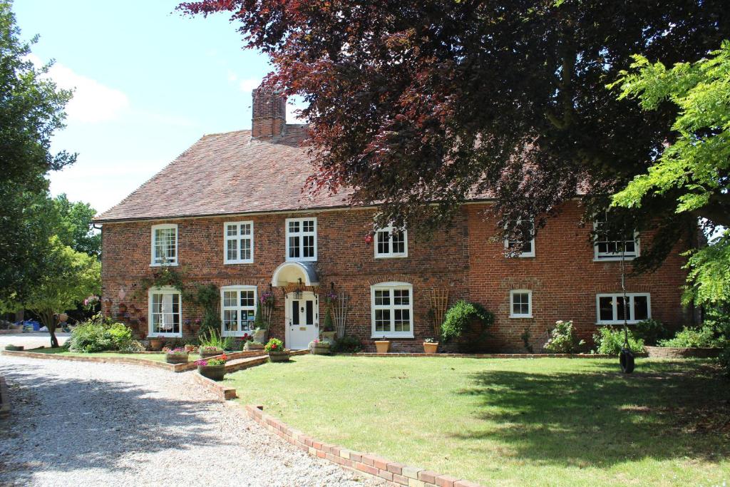 une grande maison en briques avec une cour d'herbe dans l'établissement Molland Manor House Bed & Breakfast, à Sandwich