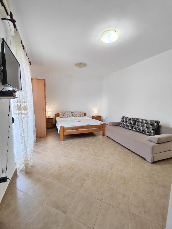 a living room with a couch and a tv at MM Apartments in Budva